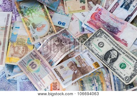 Many banknotes of different countries scattered on the table
