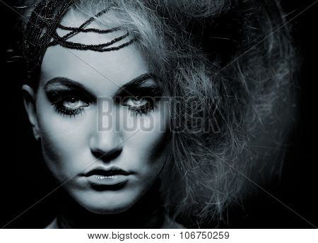 Closeup portrait of young woman in scary makeup, looking at camera.