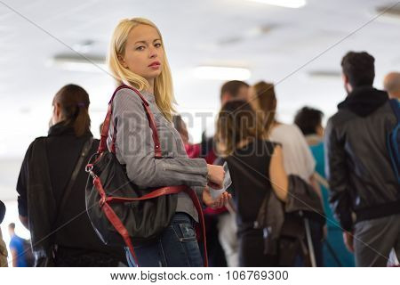 Young blond caucsian woman waiting in line.