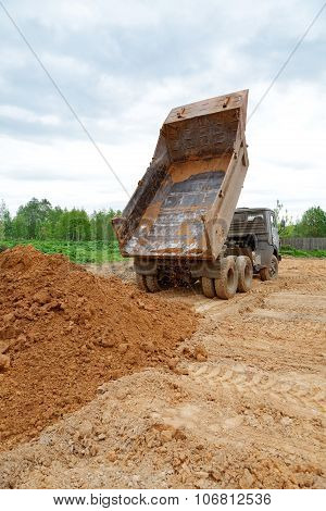 Dump-body Truck Unloads A Ground On The Land