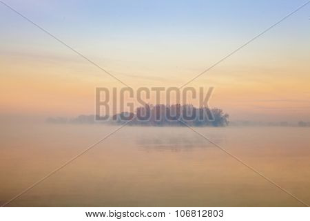 Lonely island in the fog. Sunset