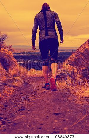 woman walking and running down a trail
