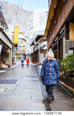 Little girl at old district of hot spring resort town Shibu onsen in Japan on winter day