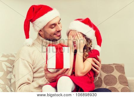 family, christmas, x-mas, winter, happiness and people concept - smiling daughter with closed eyes waiting for a present from fathe