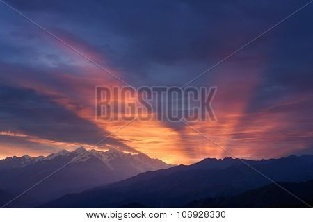 Mountain landscape at dawn. Beautiful sky with sunbeams and clouds. View from Mount Mkheer. Zemo Svaneti, Georgia 