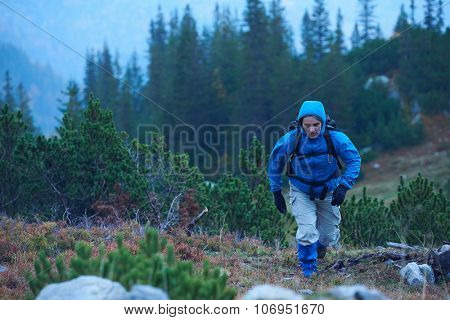 advanture man with backpack hiking on mountain forest