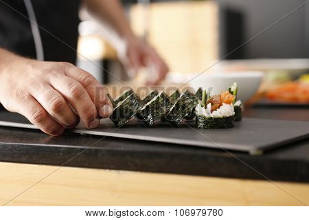 Master sushi knife slicing sushi rolls