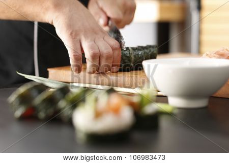 Master sushi knife slicing sushi rolls