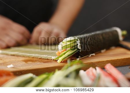 Sushi master prepares futomaki