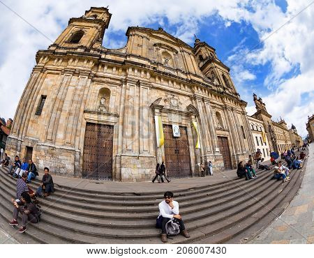 BOGOTA COLOMBIA - APRIL 23: Unidentified people relax in front of the primary cathedtral in Bolivar Square on April 23 2016 in Bogota Colombia.