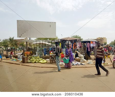 BAMAKO MALI - DEC 19 2016: View from the humanitarian vehicle of a generic urban market shopping street of the Bamako with people selling on the streets diverse object and vegetables