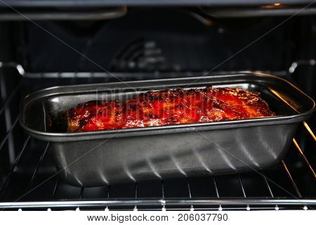 Baking dish with delicious turkey meatloaf in oven