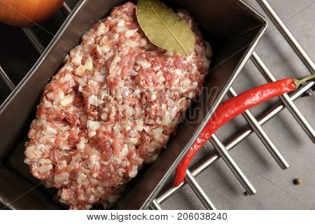 Baking dish with raw turkey meatloaf on table