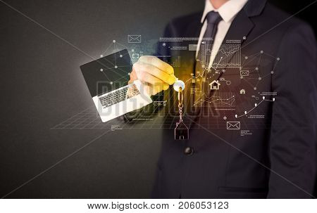 Businessman in suit holding keys with statistics, graphs and icons around