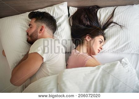 Man and woman opposite face in bed in the morning