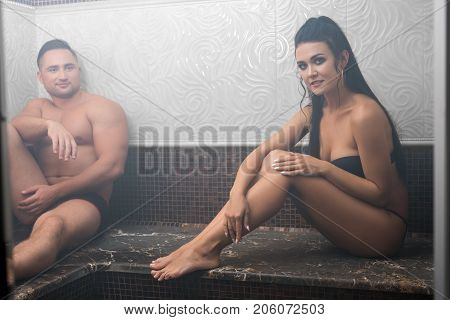 Pretty brunette in bicini spending time with her handsome boy friend in sauna