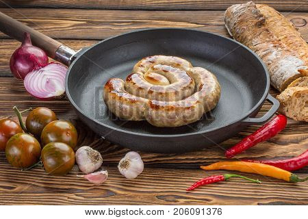 Frying pan with fried sausage vagitables and bread. Ingredients - tomatoes onion garlic chili pepper bread homemade sausage