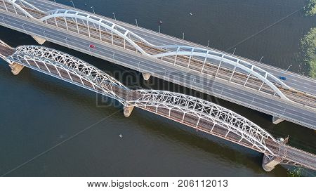 Aerial top view of automobile and railroad Darnitsky bridge across Dnieper river from above, Kiev (Kyiv) city skyline, Ukraine