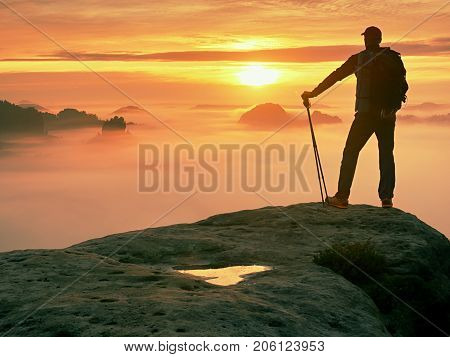 Man Silhouette With Poles In Hand. Sunny Spring Daybreak And Tourist Guide Stay On Sharp Cliff Of Mo