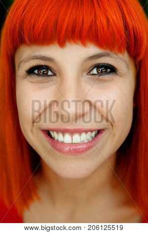 Portratit of a redhead woman, she is caring her teeth