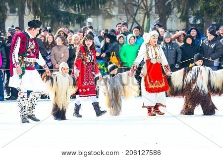 Razlog, Bulgaria - January 14, 2017: People, adults and children in traditional carnival kuker costumes at Kukeri festival Starchevata