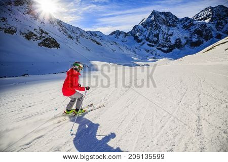 Teenager skiing in Italian Alps. In background blue sky and shiny sun and Ortler in South Tirol, Italy.  Adventure winter extreme sport. 
