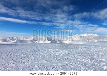 Ski Slope, Snow Mountains And Blue Sky With Clouds