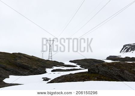 Typical norwegian landscape with snowy mountains and electric line near the famous Aurlandsvegen (Bjorgavegen), mountain road, Aurland, Norway.