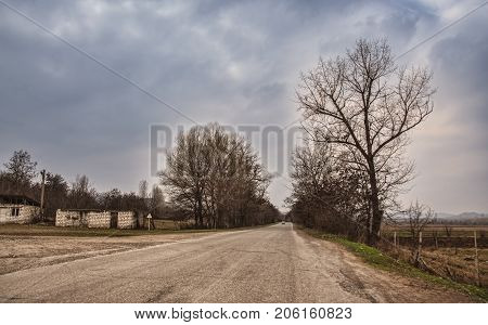 Ground Road In Village In Winter Countryside The Evening Sunlight. Atmospheric Rural Moment. Old Hou