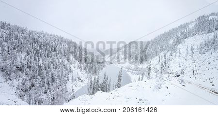 Beautiful lake Amut in taiga hills on Far East of Russia in early october. Mountain lake in winter. Beautiful nature. Snowy weather.