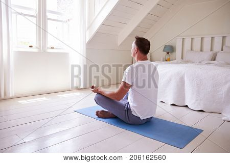 Mature Man With Digital Tablet Using Meditation App In Bedroom