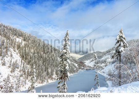 Beautiful lake Amut in taiga hills on Far East of Russia in early october. Mountain lake in winter. Beautiful nature. Snowy weather.