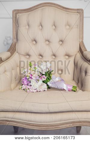 Bridal bouquet lying on the chair in white studio