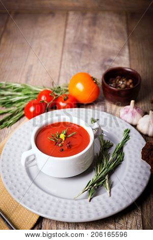 Red ukrainian borsch with sour, garlic, parsley, spices and a lot of dill and parsley on a wooden background. Copy space. Close-up of appetitzing dish. Food concept.