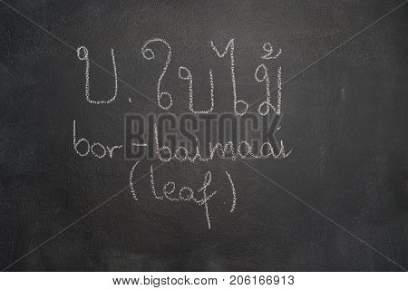 Thai letter written with white chalk on blackboard