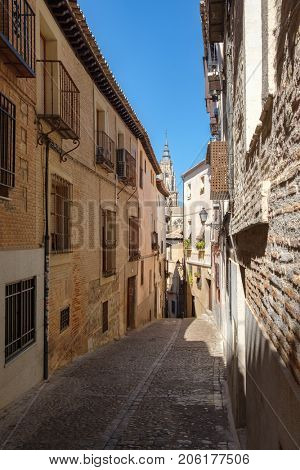 Narrow street with old buildings on the medieval city of Toledo in Spain