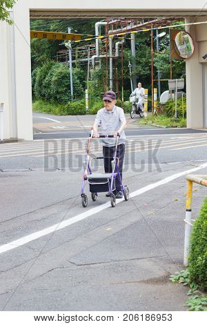 TOKYO JAPAN - SEPTEMBER 16 : unidentified asian old leprosy man walking with wheel waker for exercising in Tama Zensho Hospital on September 16 2017 in Tokyo Japan.