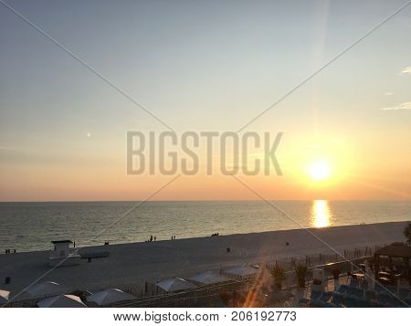 sun setting over the ocean from a hotel balcony