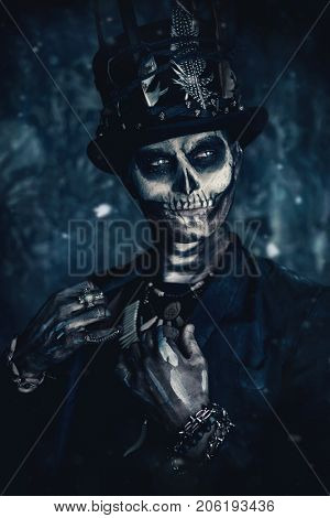 A man with a skull makeup dressed in a tail-coat and a top-hat. Baron Saturday. Baron Samedi. Dia de los muertos. Day of The Dead. Halloween.
