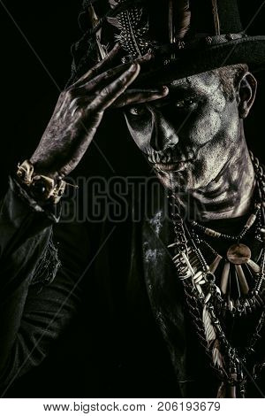 A man with a skull makeup dressed in a tail-coat and a top-hat. Baron Saturday. Baron Samedi. Dia de los muertos. Day of The Dead. Halloween.