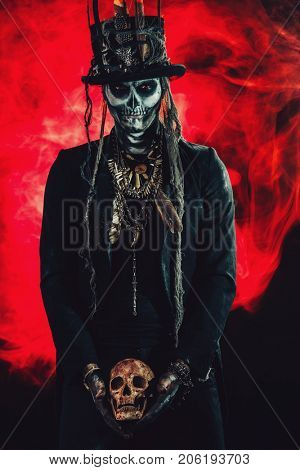 A man with a skull makeup dressed in a tail-coat and a top-hat. Baron Saturday. Baron Samedi. Dia de los muertos. Day of The Dead. Halloween.