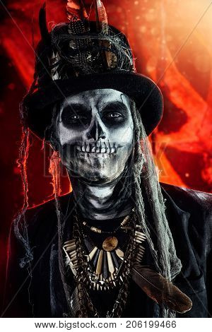 A man with a skull makeup dressed in a tail-coat and a top-hat. Baron Saturday. Baron Samedi. Dia de los muertos. Day of The Dead. Halloween.