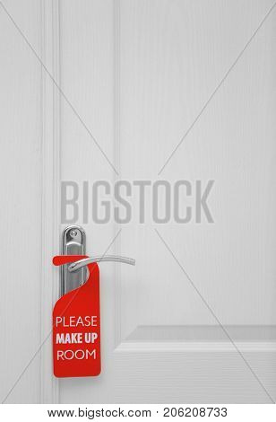 Closed door with sign PLEASE MAKE UP ROOM on handle at hotel