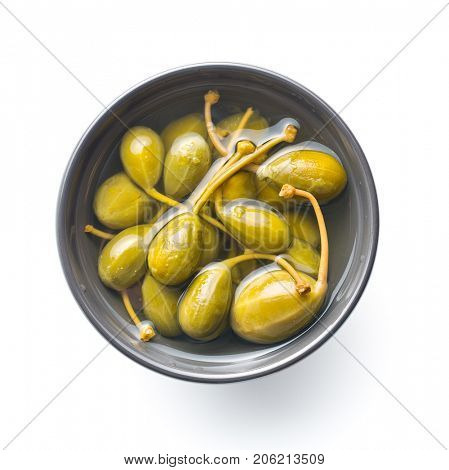 Pickled caper berries in bowl isolated on white background.