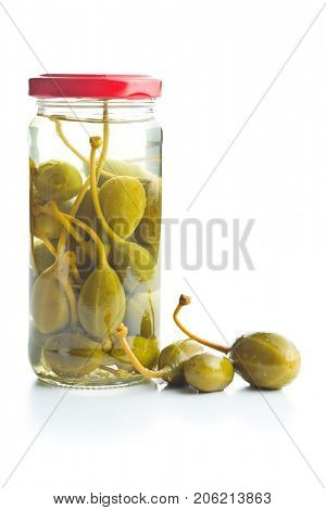 Pickled caper berries in jar isolated on white background.