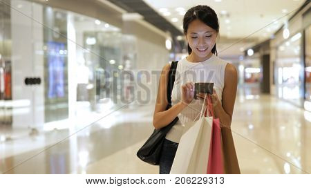 Shopping woman using smart phone at shopping center
