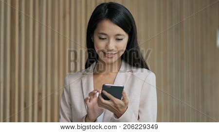 Business woman walking in the building and using cellphone 