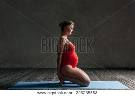 Young beautiful  pregnant yoga posing in studio