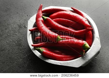 Plate with red chili peppers on gray table