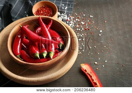 Plate with red chili peppers on table